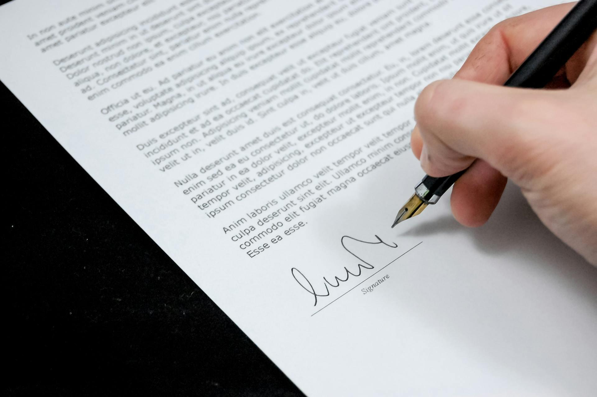Una mano firmando un documento.
